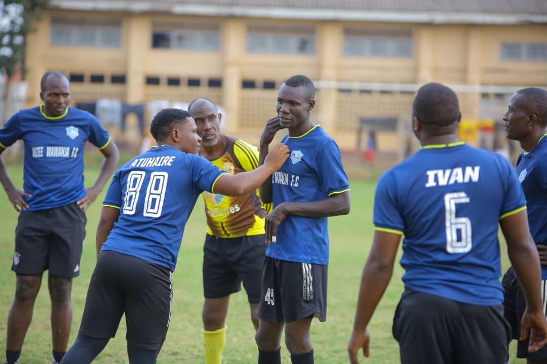 Mzee Wawanja players talking on the pitch during a match
